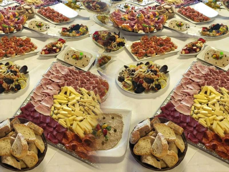 Italienisches Kalt-Buffet mit Antipasti, Schinken und Käse auf langer Tafel