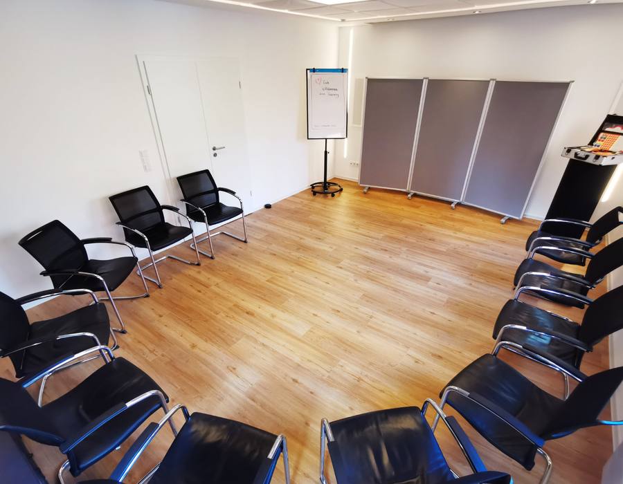 Studio im Workshop-Aufbau: offener Stuhlkreis, Flipchart und Metaplanwände